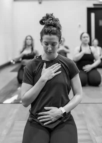 Woman doing yoga with her hand over heart