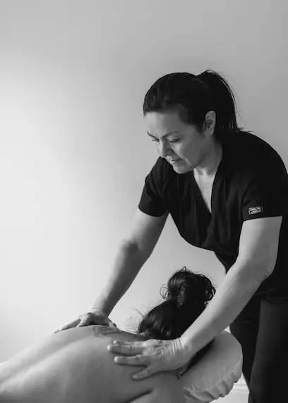 Massage therapist with her hands on a clients back